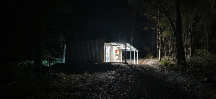 an image of the shed illuminated at night from the bottom of my driveway.