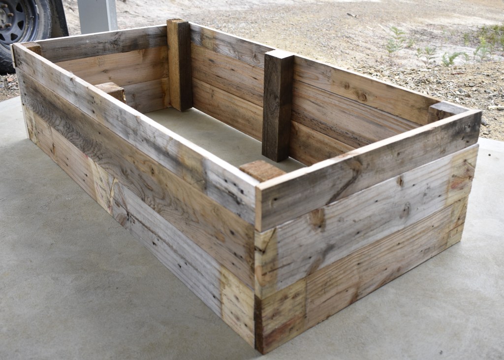 The finished product, a moderate sized raised garden bed made from reclaimed or upcycled timber pallets.