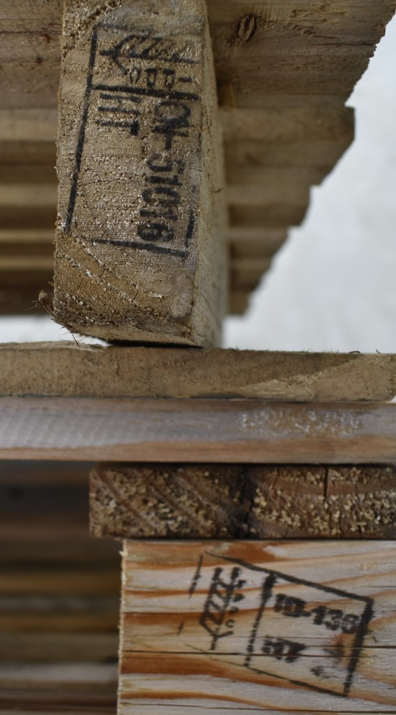 Two types of shipping pallets hot showing the HT stamp and logo, indicating that these are both heat treated.